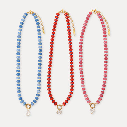 Natural stone beaded necklace with a gold ring detail and zircon drop charm in blue, red, and pink color options.