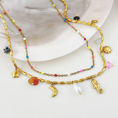Close-up of colorful beads, gold sea-inspired charms, pearl-like pendant, and 18k gold-plated stainless steel chain.