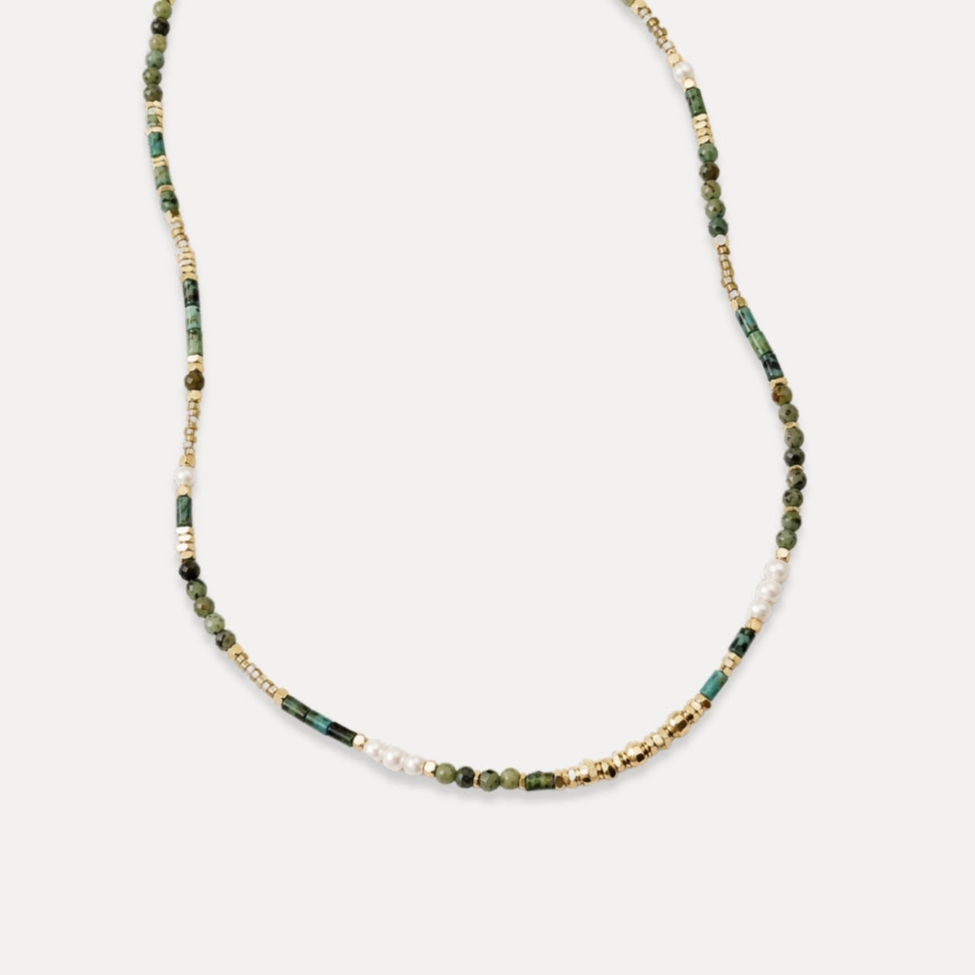 Delicate green stone freshwater pearl and gold beaded necklace on white background