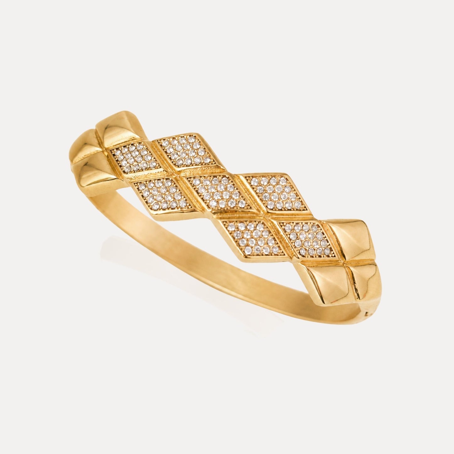 Angled view of the Woven CZ Bangle with interlocking gold geometric panels set with clear cubic zirconia